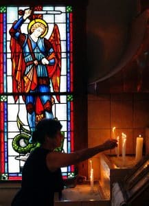 Photosinmotion.net has experience in news photography as a woman lights a candle.