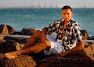 Young male model photographed in Dunedin, FL on rocks.